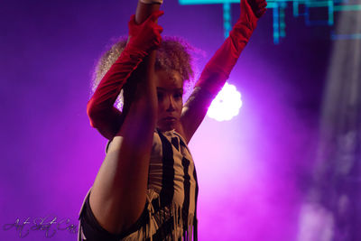 Low angle view of woman looking away at night