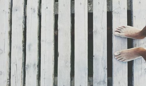 Low section of bare feet on wood paneling