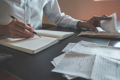 Midsection of man with text on table