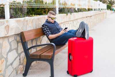 Man sitting on chair against wall