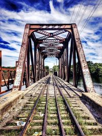 Railroad tracks against cloudy sky