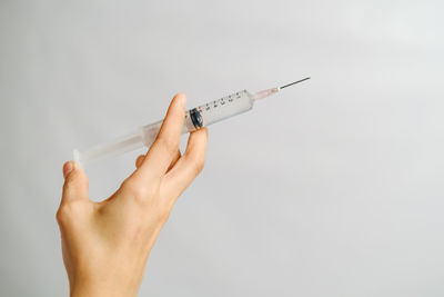 Cropped image of woman holding hands against white background