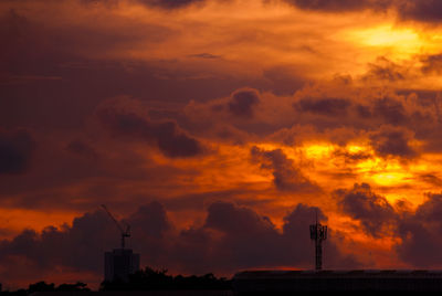 Silhouette communications tower against sky during sunset