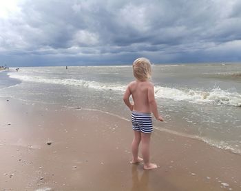 Rear view of boy standing on beach