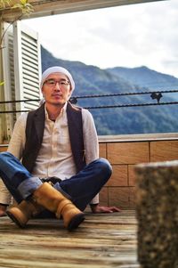 Portrait of young man sitting on railing