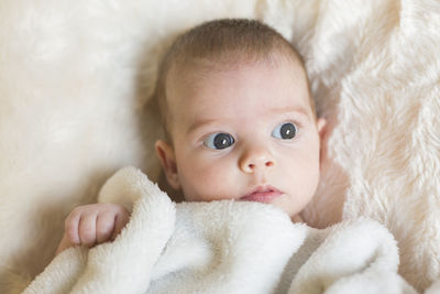 Portrait of cute baby lying on bed