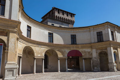 Low angle view of old building against clear blue sky