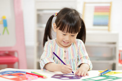 Young girl practice drawing different shapes for home schooling