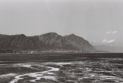 Scenic view of sea and mountains against sky