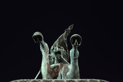 Low angle view of statue against black background