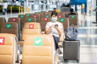 Full length of woman with mask in airport