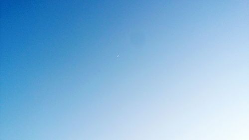 Low angle view of moon against clear blue sky