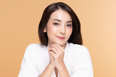 Portrait of beautiful young woman against gray background
