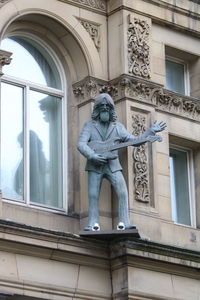 Low angle view of statue against historic building