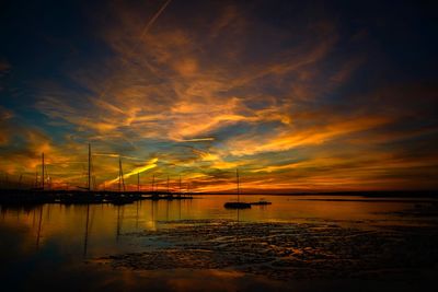 Scenic view of sea against dramatic sky during sunset