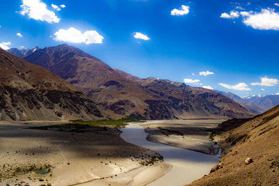 Scenic view of landscape and mountains against blue sky