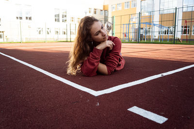 Full length of girl sitting on wall