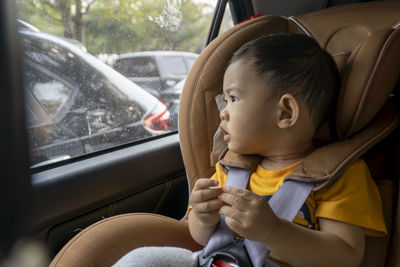 Close-up of little boy children on a car seat in the car.