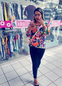 Woman standing on mobile phone at store