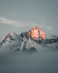 Scenic view of snowcapped mountains against sky during sunset