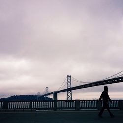 Low angle view of bridge against cloudy sky