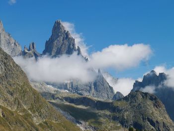 Scenic view of clouds covering rocky mountain