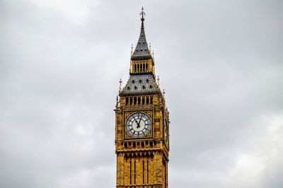 Low angle view of clock tower against cloudy sky