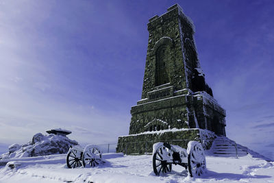 Low angle view of cross against sky during winter