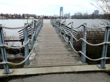 Boardwalk in city against sky