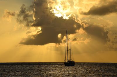 Sailboat on sea against sky during sunset