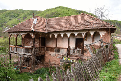 Old abandoned house on landscape against sky