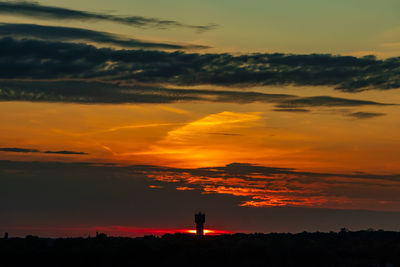 Silhouette people standing on field against sky during sunset
