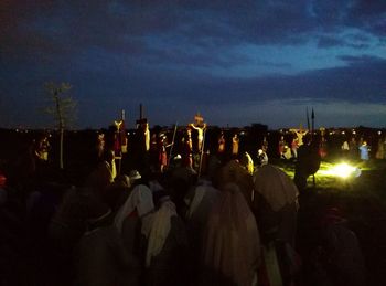 Crowd at music concert against sky at night