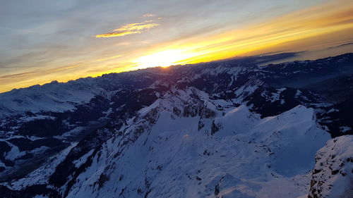 Scenic view of snowcapped mountains against sky during sunset