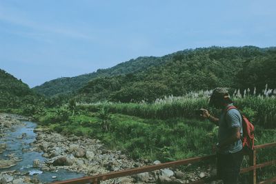 Man amidst plants and trees against sky