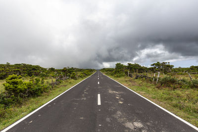 Road amidst trees against sky