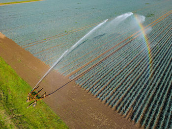 Agricultural irrigation with the sprinkler and rainbow captured from a drone