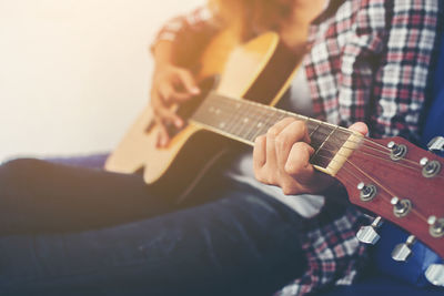 Midsection of woman playing guitar