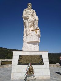 Low angle view of statue against blue sky