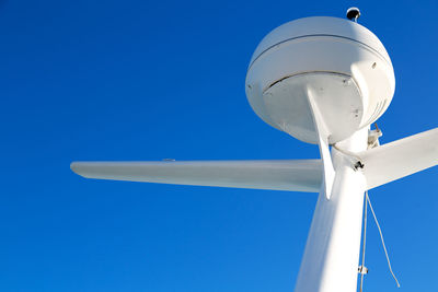 Low angle view of wind turbine against blue sky