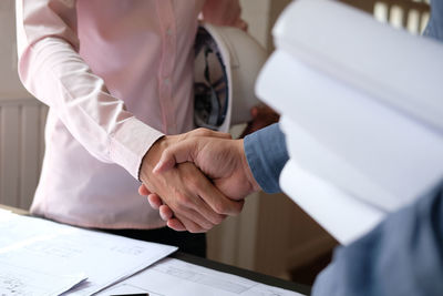 Midsection of a woman with hands on table