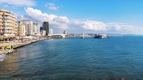 Scenic view of sea by city against sky