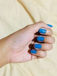 Cropped image of hand with blue nail polish