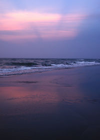 Scenic view of beach against sky at sunset