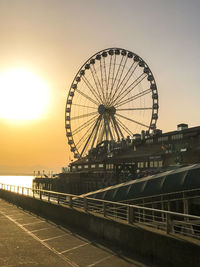 Ferris wheel against sky during sunset