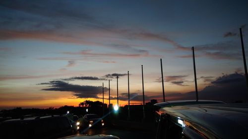 Cars on road against sky during sunset