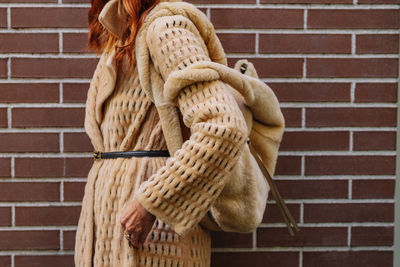 Rear view of woman standing against wall
