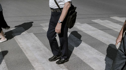 Low section of people walking on zebra crossing