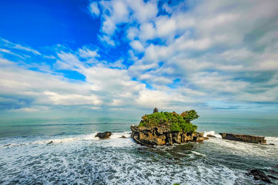 Scenic view of the temple of tanah lot in the sea against sky