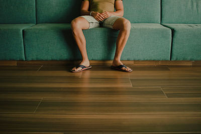 Low section of woman sitting on sofa